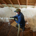 Worker installing blown insulation
