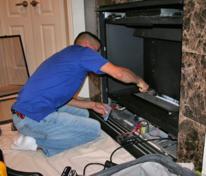 Worker servicing a gas fireplace.