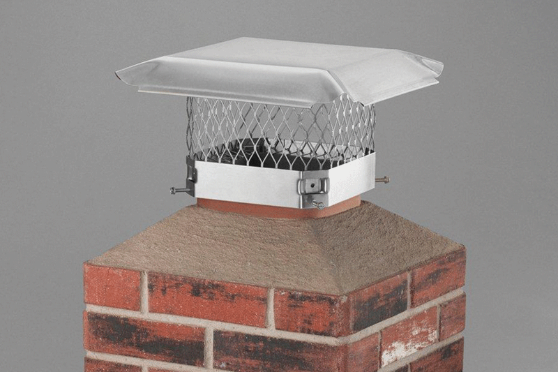 Metal chimney cap or spark arrestor on top of a brick chimney.