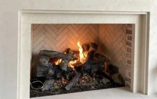 This is a Grand Oak 30" gas log set with remote control burner by Heatilator installed in a FireRock 48" California Conventional fireplace, the fireplace features a herringbone pattern with buff brick interior