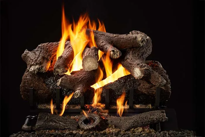 Heritage Oak 2-Tier Remote Control Gas Log Set with hand-painted oak logs, glowing ember bed, and bright flames against a black background.