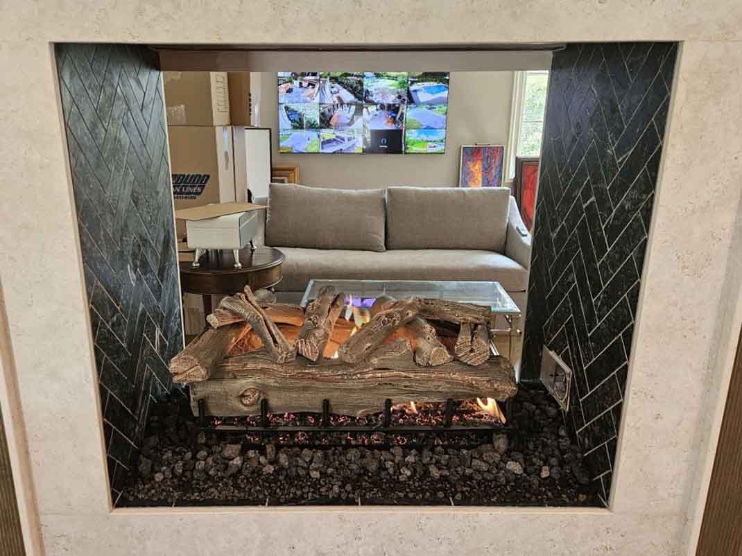 Isokern Magnum 48 see-through pre-engineered masonry fireplace. Isokern Magnum 48 see-through pre-engineered masonry fireplace with soapstone split interior brick and Grand Canyon Western Driftwood 36-inch gas log set on display at Perfection Supply Houston showroom.