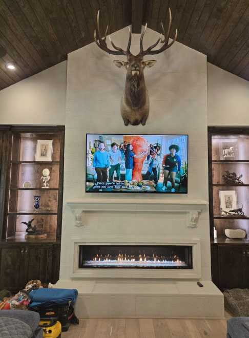 Heat & Glo Mezzo 72-inch linear gas fireplace with a clean-face front set in a white stone surround below a mounted TV. Heat & Glo Mezzo 72-inch linear gas fireplace with a clean-face front set in a white stone surround below a mounted TV in a vaulted living room in Cove, TX.